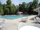 A community pool with lounge chairs, tables, and a picnic building sits nestled amongst the trees at 124 Ripley Ct, Cary, NC 27513
