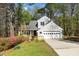 Inviting home featuring a two-car garage, a wooden deck, and mature trees surrounding the property at 124 Ripley Ct, Cary, NC 27513
