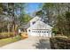 Home featuring an attached garage and a charming wooden deck with lush trees in the surrounding landscape at 124 Ripley Ct, Cary, NC 27513