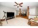 Living room featuring beige carpet, a ceiling fan, and open view to the adjacent kitchen at 124 Ripley Ct, Cary, NC 27513