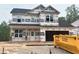 New construction two-story home with black roof, visible framing, and attached garage awaiting finishing touches at 13 Fetterbush Way, Clayton, NC 27520