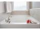 Serene bathroom featuring a soaking tub with tile surround, providing a luxurious and relaxing bathing experience at 1415 Dalton Pl, Mebane, NC 27302