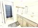 Bright bathroom featuring a double vanity, decorative mirror, and shower with a blue curtain at 1415 Dalton Pl, Mebane, NC 27302
