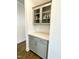 Elegant butler's pantry featuring gray cabinetry, glass-front cabinets, white countertops, and stylish tile backsplash at 1415 Dalton Pl, Mebane, NC 27302
