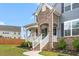 Charming front entrance with stone archway, white railings, and flowers, creating a welcoming and inviting curb appeal at 1415 Dalton Pl, Mebane, NC 27302