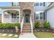 Inviting front entrance with stone steps, a welcoming wreath, and blooming flowers, creating a warm and inviting atmosphere at 1415 Dalton Pl, Mebane, NC 27302