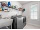 Bright laundry room with utility sink, shelving for storage, and modern washer and dryer at 1415 Dalton Pl, Mebane, NC 27302