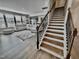 Sunlit living room with staircase features a comfortable couch and large windows at 1415 Dalton Pl, Mebane, NC 27302