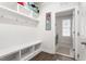 Bright mudroom features built-in bench with storage, shelves, coat hooks, and doorway to the laundry room at 1415 Dalton Pl, Mebane, NC 27302