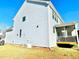 View of back of home with light grey siding, brick foundation and screened-in porch and deck at 1415 Dalton Pl, Mebane, NC 27302
