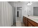 Bathroom with a double vanity, neutral tile and view to an adjacent bedroom at 150 Alamosa Pl, Cary, NC 27519