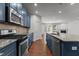 Contemporary kitchen showcasing stainless steel appliances, granite counters, and beautiful blue cabinetry at 150 Alamosa Pl, Cary, NC 27519