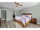 Bright bedroom features a ceiling fan, tray ceiling, and an attached bathroom at 1527 Ingraham Dr, Apex, NC 27502