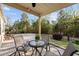 View of covered patio with outdoor seating, overlooking a landscaped backyard with mature trees at 1527 Ingraham Dr, Apex, NC 27502