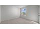 A bedroom with neutral carpet and white walls features a window at 200 Olive Branch St, Sanford, NC 27332