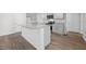 Modern kitchen with an island, granite countertops, stainless steel appliances, and vinyl flooring at 200 Olive Branch St, Sanford, NC 27332