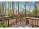 View of backyard with wooden fence and deck, surrounded by trees, offering privacy and a natural setting at 202 Lighthouse Way, Cary, NC 27511