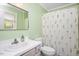 Fresh bathroom with a floral shower curtain, vanity and a large mirror at 202 Lighthouse Way, Cary, NC 27511