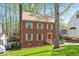 Attractive brick house surrounded by mature trees and lush greenery at 202 Lighthouse Way, Cary, NC 27511