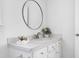 Well-lit bathroom featuring a round mirror and white countertop vanity at 2020 Battlewood Rd, Apex, NC 27523