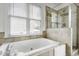 Bathroom with soaking tub, separate glass shower, and window for natural light at 2020 Battlewood Rd, Apex, NC 27523