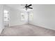 Spacious carpeted bedroom with natural light and a ceiling fan at 2020 Battlewood Rd, Apex, NC 27523