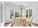 Well lit Dining Room featuring a round table, four chairs, light fixture, and view of the wooded backyard at 2020 Battlewood Rd, Apex, NC 27523