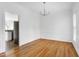Bright dining room with hardwood floors, wainscoting, and a modern chandelier at 2020 Battlewood Rd, Apex, NC 27523