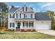 Charming two-story home with blue shutters, a front porch, and a well-manicured lawn at 2020 Battlewood Rd, Apex, NC 27523