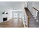 Bright, open living room with hardwood floors, a fireplace, and a staircase at 2020 Battlewood Rd, Apex, NC 27523