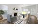 Staged living room with fireplace, neutral furniture, hardwood floors, and large windows. Virtually Staged at 2020 Battlewood Rd, Apex, NC 27523