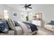 Staged bedroom with natural light, ceiling fan, and neutral color palette at 2020 Battlewood Rd, Apex, NC 27523