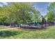 Community playground with green play structure, surrounded by a black fence at 2020 Battlewood Rd, Apex, NC 27523