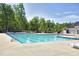 Community pool with blue water and chairs surrounded by trees at 2020 Battlewood Rd, Apex, NC 27523