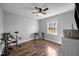 Bedroom with wood floors, ceiling fan, a window, a desk and chair, and an electronic drum set at 206 Herronwood Dr, Graham, NC 27253
