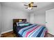 Bedroom with ceiling fan, wood-look floors, a window, and colorful striped bedding at 206 Herronwood Dr, Graham, NC 27253