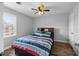 Bedroom with wood floor, window, striped bedding, and a ceiling fan at 206 Herronwood Dr, Graham, NC 27253