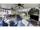 Spacious covered deck with ceiling fans, comfortable seating, and an outdoor dining area at 206 Herronwood Dr, Graham, NC 27253