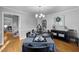 Formal dining room with hardwood floors, set table, and view to kitchen and staircase at 206 Herronwood Dr, Graham, NC 27253