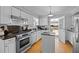 Bright kitchen featuring white cabinets, stainless steel appliances, and hardwood floors at 206 Herronwood Dr, Graham, NC 27253