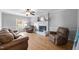 Cozy living room with hardwood floors, a white brick fireplace, and comfortable leather seating at 206 Herronwood Dr, Graham, NC 27253