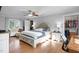 Primary bedroom with large bed, walk in closet, hardwood floors, and bright windows at 206 Herronwood Dr, Graham, NC 27253