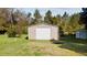 Metal outbuilding with drive-in door, ideal for storage and workspace in a backyard setting at 206 Herronwood Dr, Graham, NC 27253