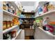 Walk-in pantry with abundant shelving space and a variety of canned goods and food items at 206 Herronwood Dr, Graham, NC 27253