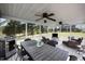 Inviting screened-in porch featuring a dining area, cozy seating, and ceiling fans overlooking the expansive yard at 206 Herronwood Dr, Graham, NC 27253