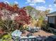 Backyard patio features blue seating, a brick surface, and a maple tree at 207 Grand Ave, Raleigh, NC 27606