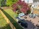 Aerial backyard view features blue seating, a brick surface, lawn, and privacy fencing at 207 Grand Ave, Raleigh, NC 27606