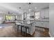 Open-concept kitchen featuring a large island with seating, white cabinets, stainless steel appliances, and hardwood floors at 207 Grand Ave, Raleigh, NC 27606