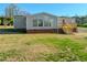 Back of house with a wooden deck and green lawn on a sunny day at 210 Holloway Rd, Roxboro, NC 27573