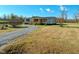 Exterior view of a home featuring a long gravel driveway and well-maintained lawn at 210 Holloway Rd, Roxboro, NC 27573